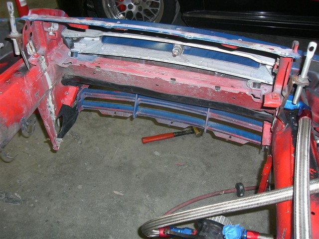 Removed the radiator bracketry to facilitate moving the rad forward in the chassis, and also the old hood latch support is gone to give room for the air intake plumbing.