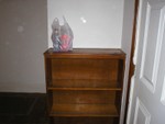 Nice wooden bookshelf built into the wall behind the front door.