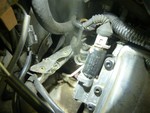 The oil leak here is bad enough that smoke is comming through the gap in the gasket. The VVT unit in question is the black round bit and the aluminum part with three black bolts in it.