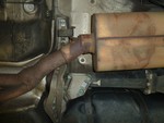 Exhaust welded into muffler with a 45 degree hard angle where it should be bent. Note the rusty steel tubing and steel muffler that has been grafted to the factory brown stainless steel tubing at the left of the picture.