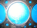 The metal gasket is under my burned MC gasket. Notice how ovaled the bore is on the MC gasket. A BRAND NEW replacement was identical.