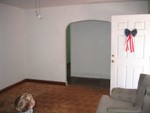 Living room. Front door is the onev open. Forward is the hall, to the right down that hall is the kitchen, to the left the bedrooms.