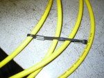 Starting at one side feed the zip tie arround the wire then back through the hose section.